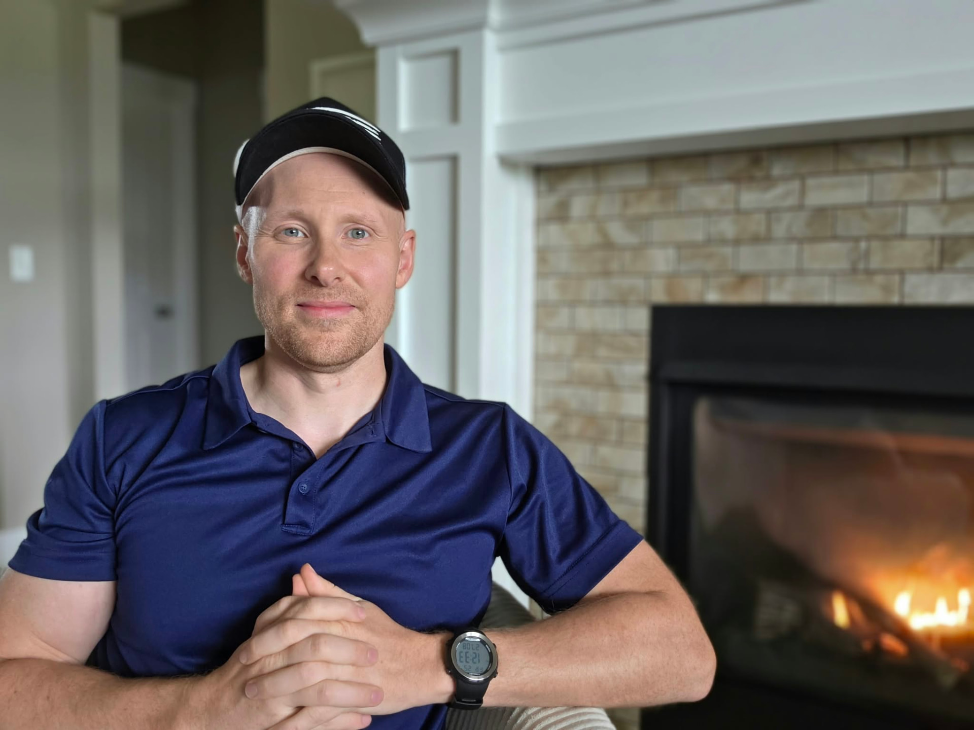 Derek James seated beside his fireplace